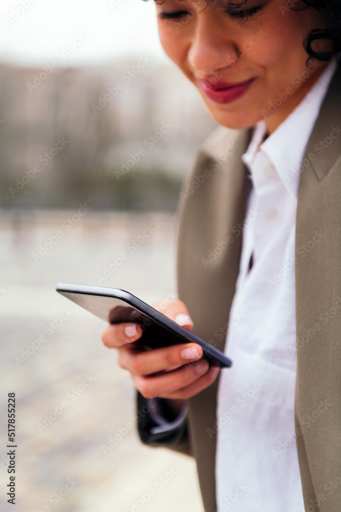 detail of the hand of a young latin woman using a mobile phone, concept of communication and urban lifestyle, copy space for text detail of the hand of a young latin woman using a mobile phone, concept of communication and urban lifestyle, copy space for text