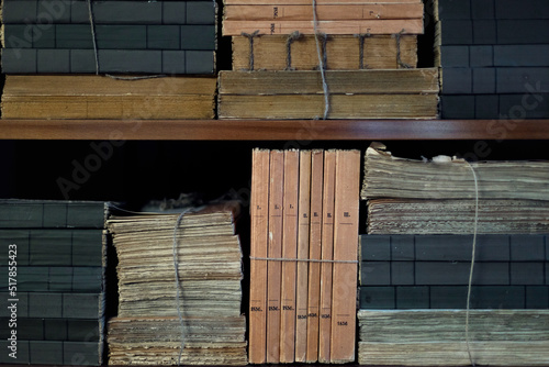 Photos A huge pile of files and documents on the shelves in a bookcase, the concept of