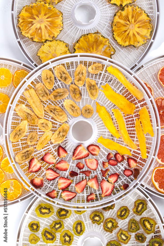 electric dryer for fruits and vegetables, close-up, bananas, strawberries, pineapple, kiwi, orange and grapefruit are on a round grate