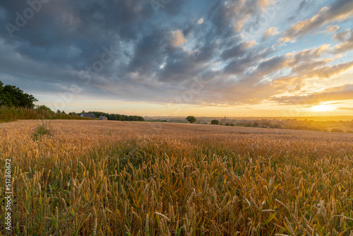 Colourful sunrise in the only Dutch mountain village located in the south of Limburg  with a view on a spectacular sky  the tower of the catholic church   the vineyards and agricultural grain fields 