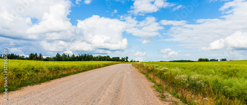 Banner.Country rural sandy road near fields trees.Summer landscape taken at good cloudscape weather.