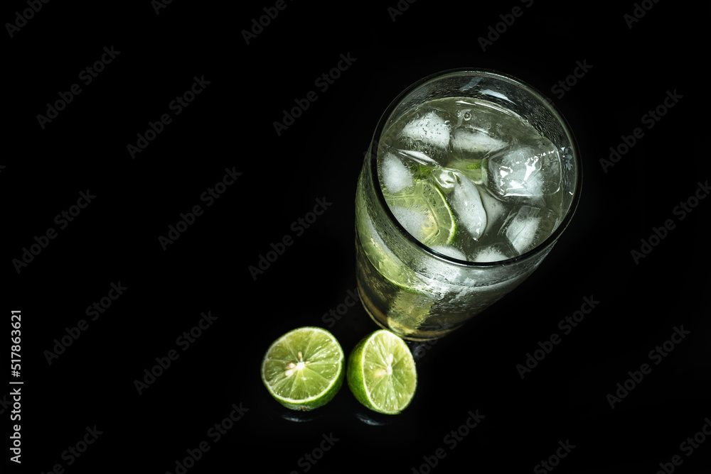 Glass of cold lemonade on black table. Ice cold drink on dark background. Glass of cold lemonade on black table. Ice cold drink on dark background.