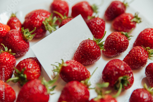 red strawberries on a white background and a business card in white