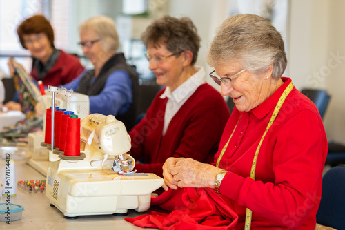 group of older ladies sewing with machines