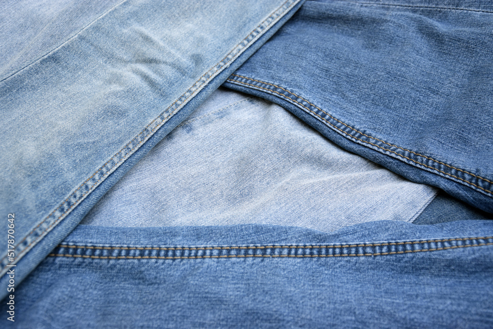 Fototapeta premium Lots of jeans pants in a stack. Denim background.