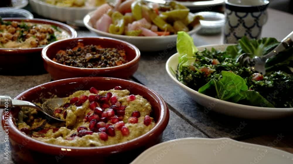 Arabic food mezze dishes on dining table. Middle Eastern cuisine served in small bowls and plates. Food footage in slow motion Arabic food mezze dishes on dining table. Middle Eastern cuisine served in small bowls and plates. Food footage in slow motion