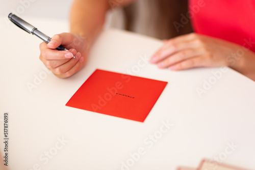 hands with pen and envelope with name written on it photo
