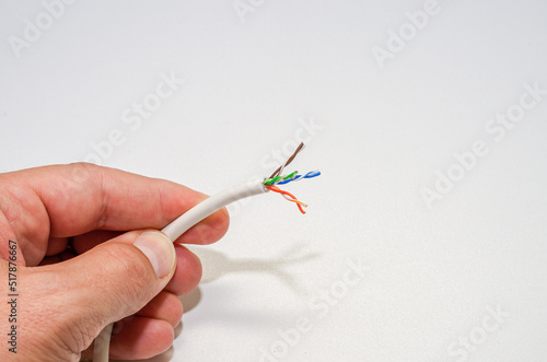 A computer wizard strips the wires of an Internet cable for connecting a twisted pair cable to a jack RJ-45 photo