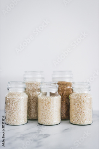 glass jar with rice of different varieties including jasmine basmati arborio sushi and brown rice, healthy pantry ingredients