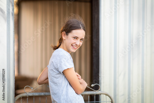 girl at gate looking bashfully at camera photo