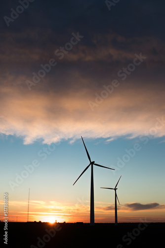 Wind farm in agricultural landscape, sunset wind turbines producing electricity, wind energy is renewable energy, clean, renewable energy source, wind turbines against the setting sun