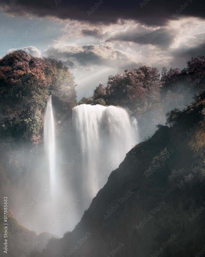 dreamy waterfall in mountains cloudy sky