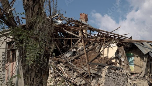 A tree stands in front of a destroyed primary school that was hit with a Russian missile during the war in Ukraine. photo