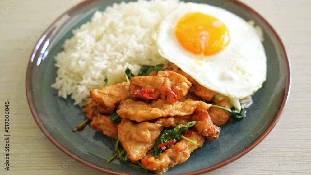 stir-fried fried fish with basil and fried egg topped on rice - Asian food style stir-fried fried fish with basil and fried egg topped on rice - Asian food style