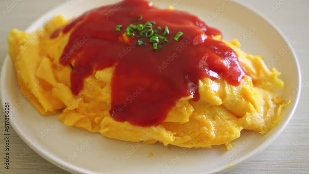 Flavored Fried Rice in an Omelet Wrapping or Omurice in Japanese style - Asian food style Flavored Fried Rice in an Omelet Wrapping or Omurice in Japanese style - Asian food style