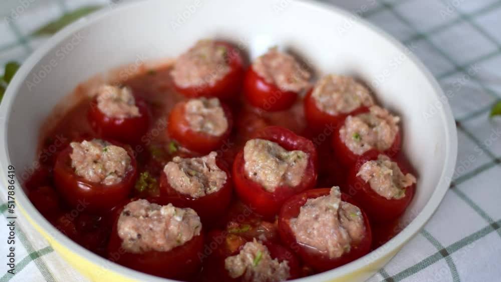Cooking stuffed tomatoes. Putting tomato halves with ground meat into the sauce in the pan. Preparing hot meal. Step by step recipe Cooking stuffed tomatoes. Putting tomato halves with ground meat into the sauce in the pan. Preparing hot meal. Step by step recipe
