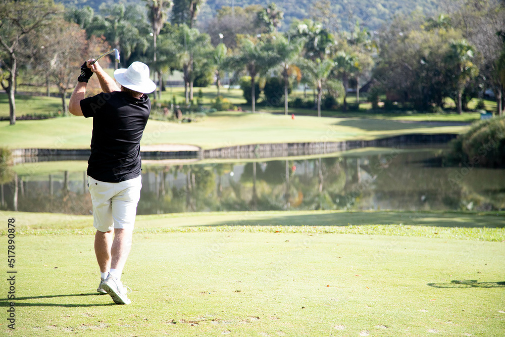 person playing golf on a golf course person playing golf on a golf course
