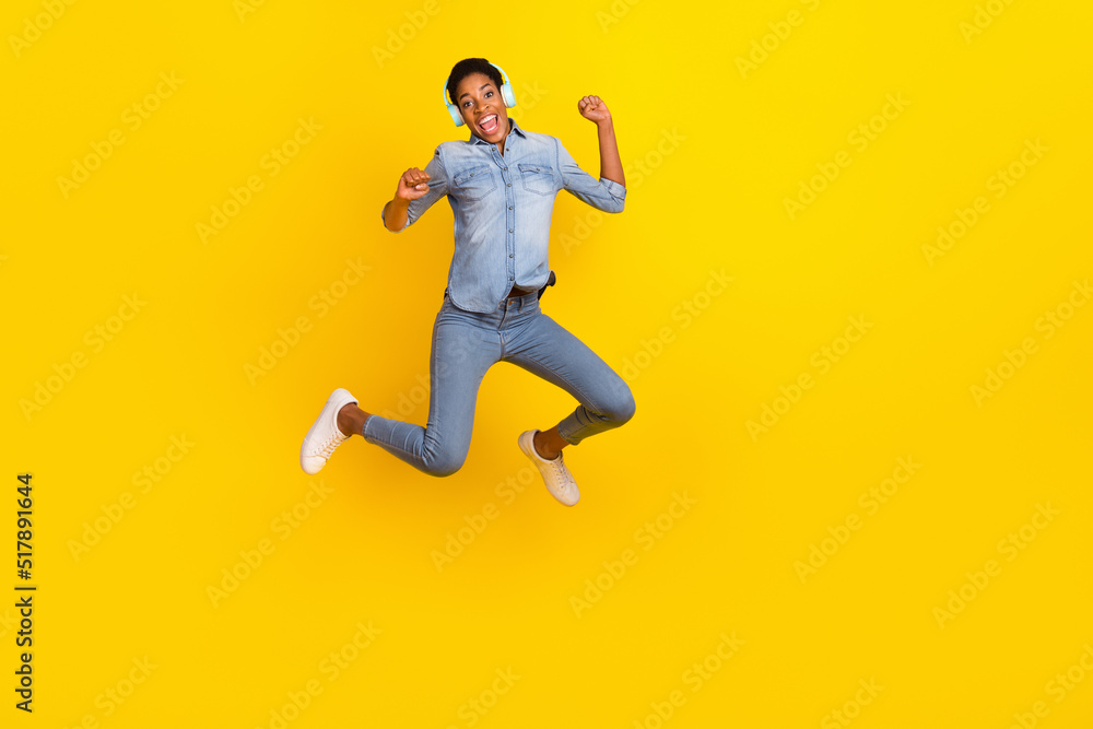 Full size photo of excited crazy person raise fists listen favorite song isolated on yellow color background Full size photo of excited crazy person raise fists listen favorite song isolated on yellow color background