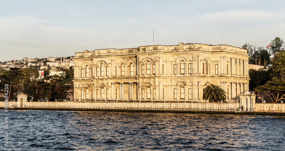 Beylerbeyi Palace on the coastline of Bosporus strait in golden hour. View from touristic boat on Bosporus. Istanbul, Turkey