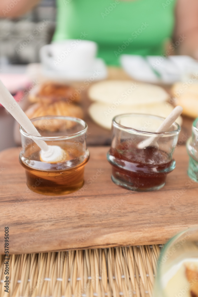 Sweet honey and jam served on transparent glasses on a breakfast table Sweet honey and jam served on transparent glasses on a breakfast table