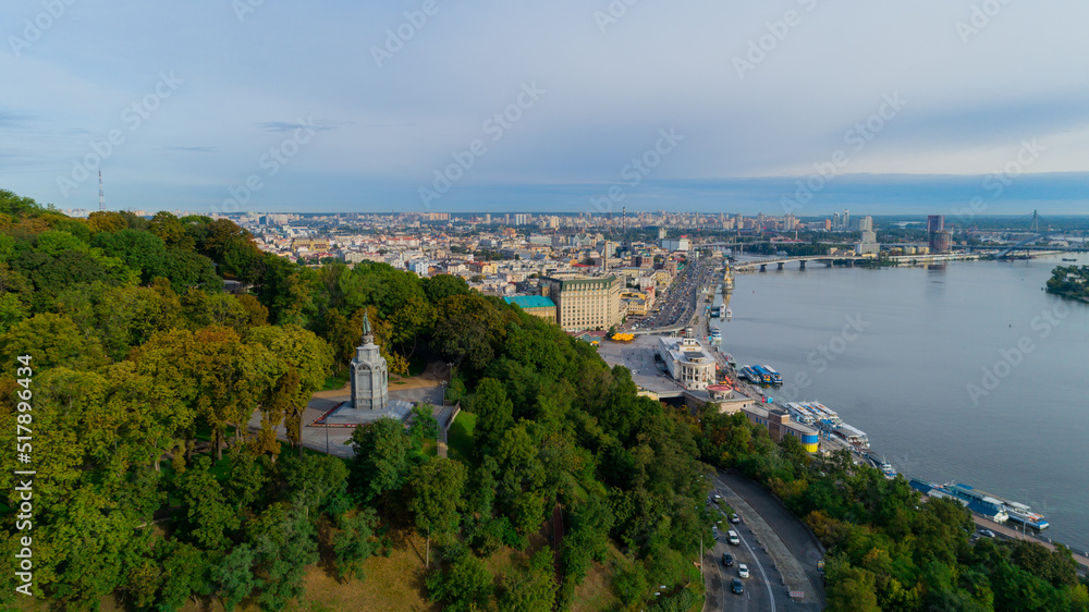 Aerial view monument to Volodymyr Velykyi on Volodymyr Hill in middle trees. Volodymyr Great. Drone shot river station, postal area on a sunny spring day. Dnipro river. Capital of Ukraine