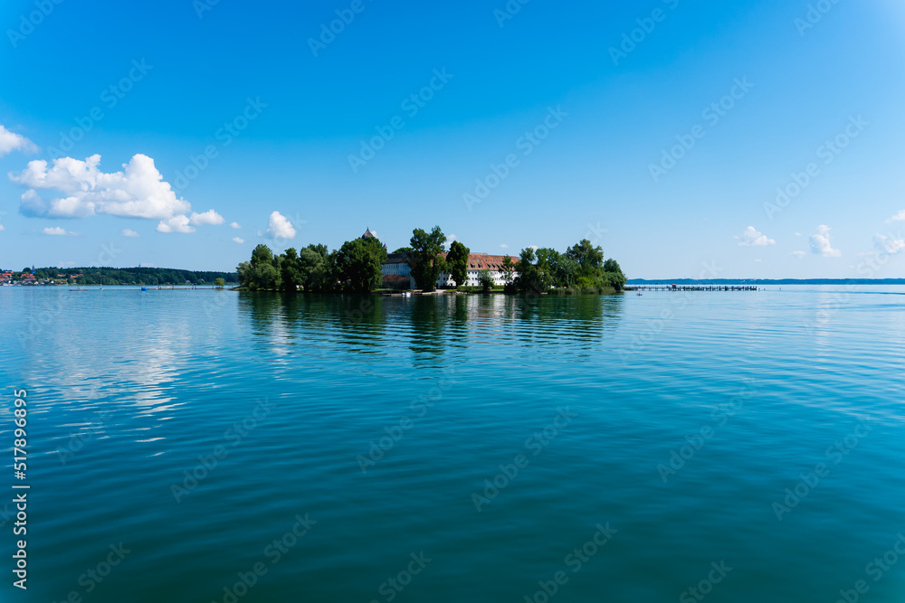 Obraz premium Fraueninsel panorama at summer with a blue sky and sun