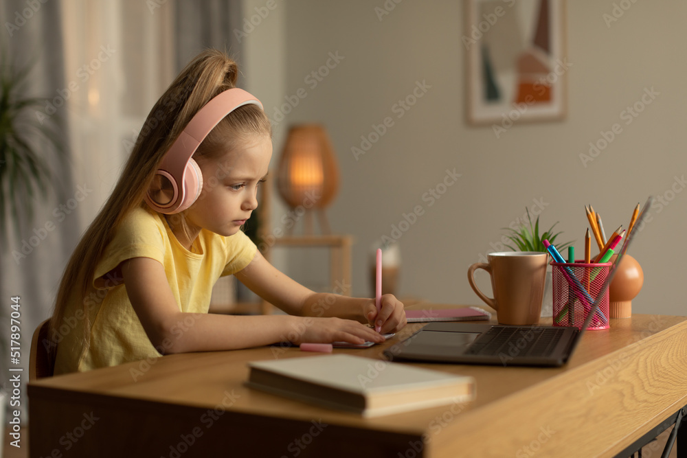 Schoolgirl Using Laptop And Taking Notes Doing Homework At Home Schoolgirl Using Laptop And Taking Notes Doing Homework At Home