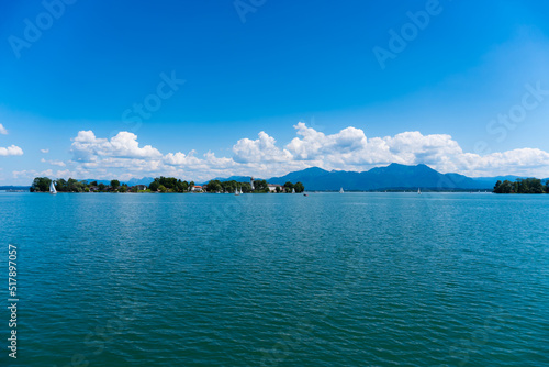 Fraueninsel panorama at summer with a blue sky, sun and mountains