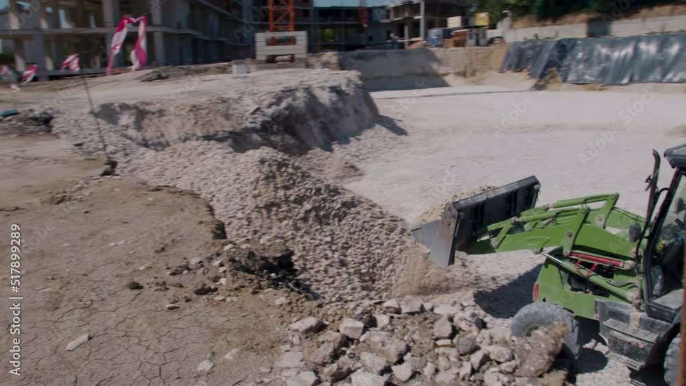 tractor for green construction on tires, in a construction site loading and unloading stone tractor for green construction on tires, in a construction site loading and unloading stone