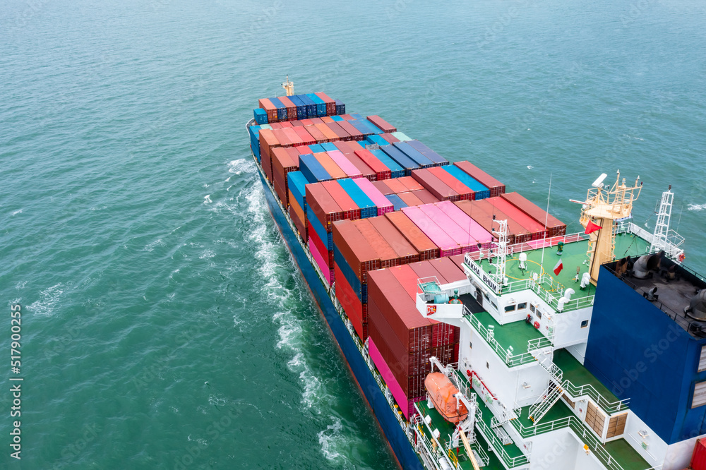 Fototapeta premium aerial back view of container ship carrying cargo container import export internatioonal and worldwide, business and industry goods logistic transportation by container ship in open sea,