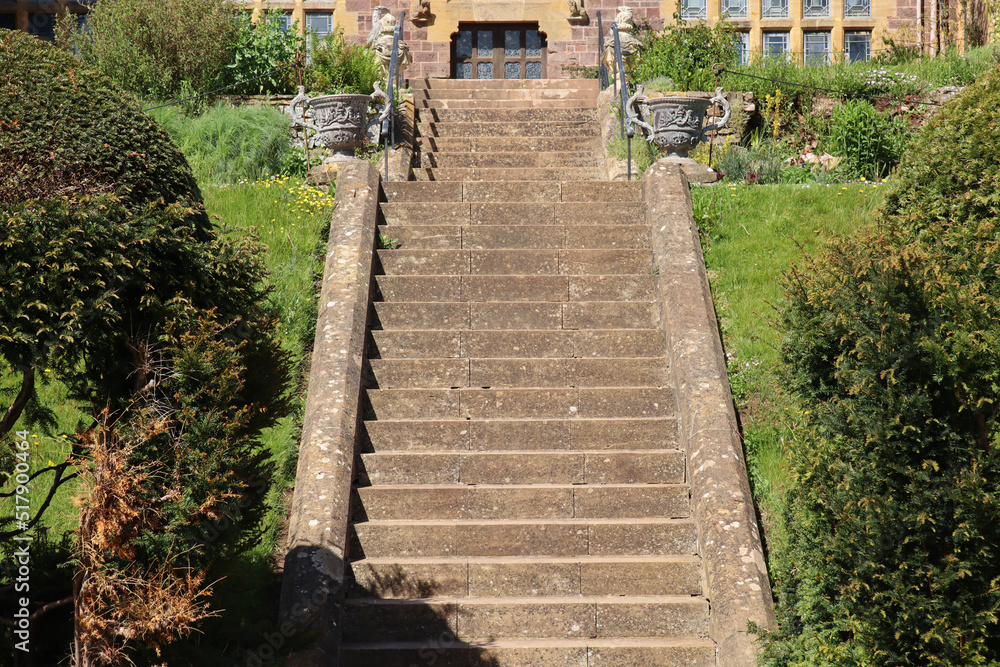 Two flights of stone steps lead up to an English stately home