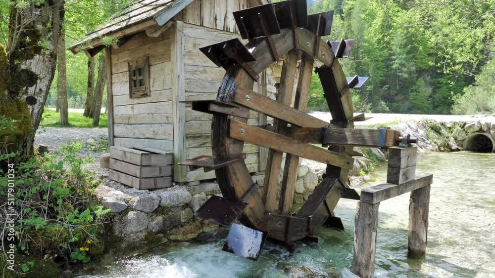 Old wooden mil with small stream and nice background with trees and rocks in Slovenia, Lake Jasna. 4k 50 fps shot