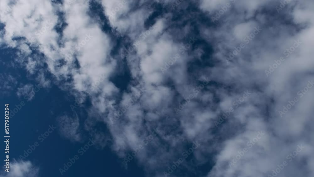 Light white clouds fly across a bright blue sky. Clear sky at sunny summer afternoon. Summer cloudscape background. Copy space Light white clouds fly across a bright blue sky. Clear sky at sunny summer afternoon. Summer cloudscape background. Copy space