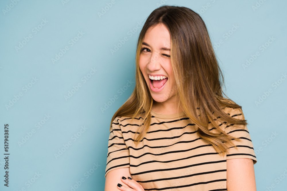 Woman winking and flirting in a studio Woman winking and flirting in a studio