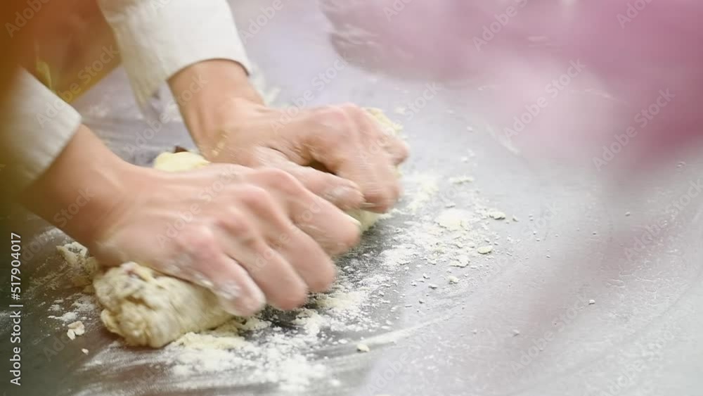 Female hands kneading dough on the table, slow motion. Female hands kneading dough on the table, slow motion.