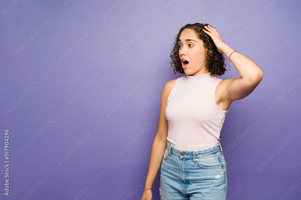 Beautiful woman receiving surprising good news against a purple background with copy space Beautiful woman receiving surprising good news against a purple background with copy space