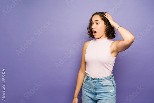 Beautiful woman receiving surprising good news against a purple background with copy space