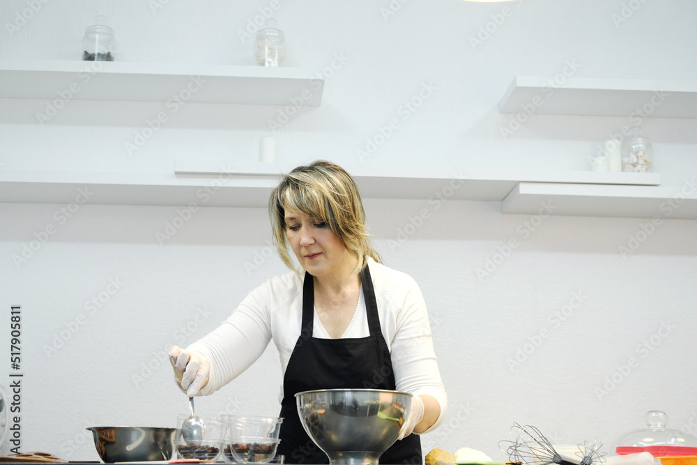 The process of preparing a multi-layered dessert..The confectioner puts the biscuit as the bottom layer. The process of preparing a multi-layered dessert..The confectioner puts the biscuit as the bottom layer.
