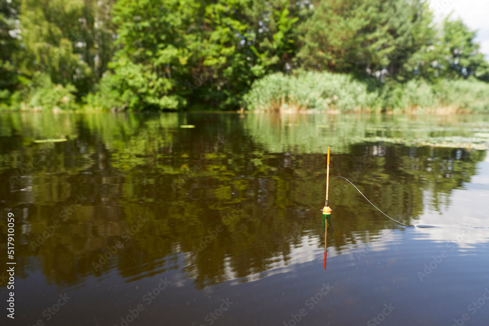 Close up view of fishing float on the river in summer time. Close up view of fishing float on the river in summer time.