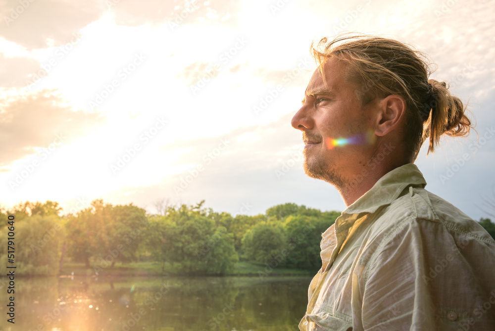 Blond man is resting at the lake at sunlight in summer. Blond man is resting at the lake at sunlight in summer.