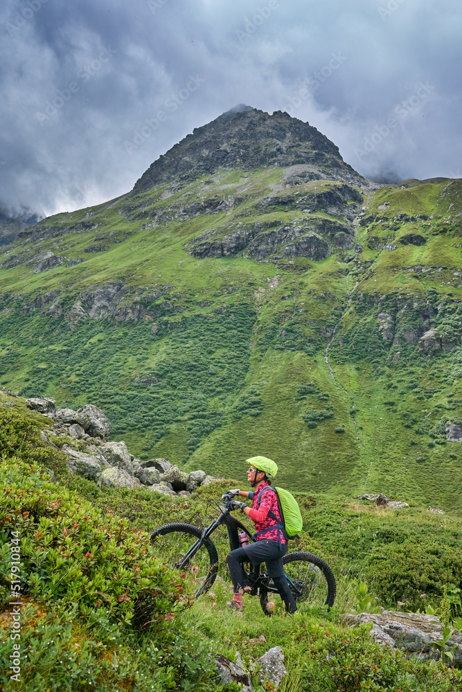 Obraz premium nice active senior woman riding her electric mountain bike in the silvretta mountain range near Gaschurn, Tyrol, Austria