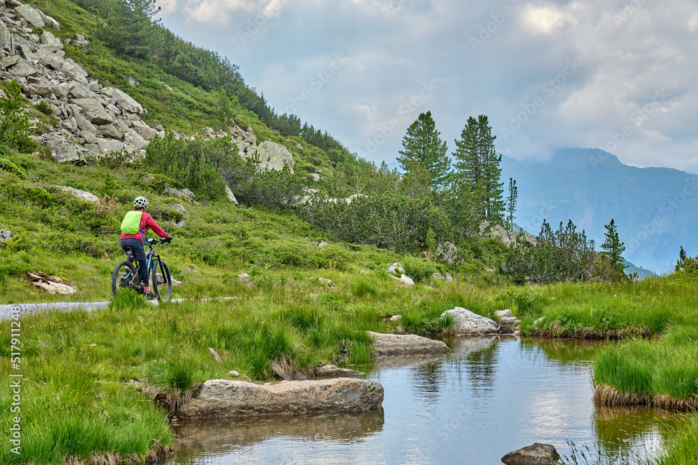 nice active senior woman riding her electric mountain bike in the silvretta mountain range near Gaschurn, Tyrol, Austria