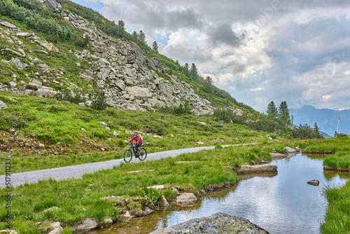 nice active senior woman riding her electric mountain bike in the silvretta mountain range near Gaschurn, Tyrol, Austria