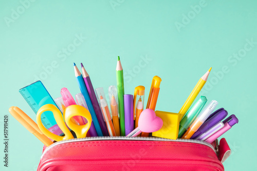 Back to school concept. Bright school pencil case with filling school stationery, pens, pencils, scissors, rule. School accessories on blue background. Flat lay, top view, copy space photo