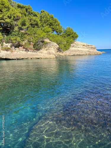 Beautiful blue turquoise sea clear water in scenic bay at summer. Pine rocky island in the sea.