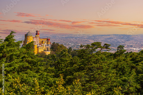 Famous historic Pena palace part of cultural site of Sintra against sunset sky in Portugal.