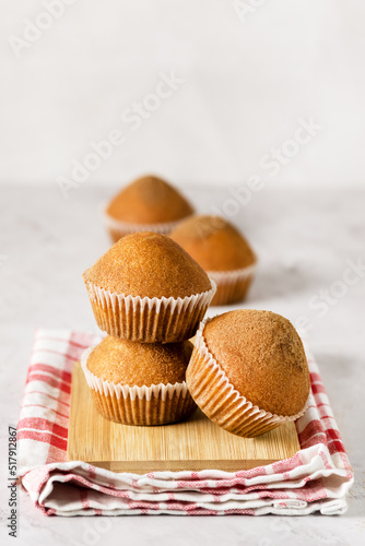 Stacked Tasty Vanilla Muffins on Wooden Tray Gray Red Linen Napkin Background Vertical