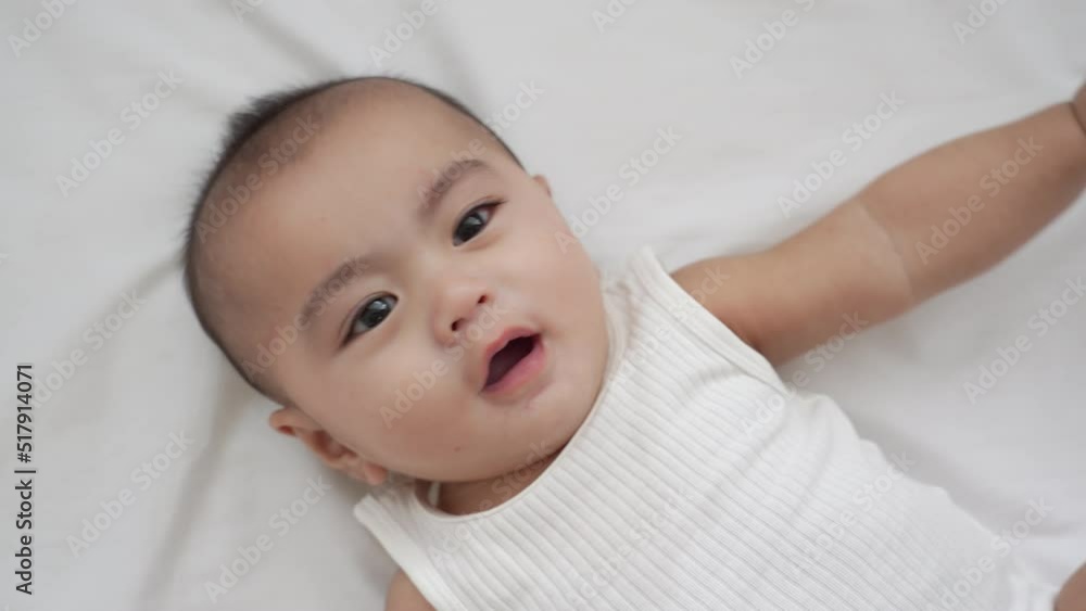 Smiling of newborn baby or cute little lying on a white bed at home. Infant child portrait happy concept, Healthy childcare in the morning. Smiling of newborn baby or cute little lying on a white bed at home. Infant child portrait happy concept, Healthy childcare in the morning.