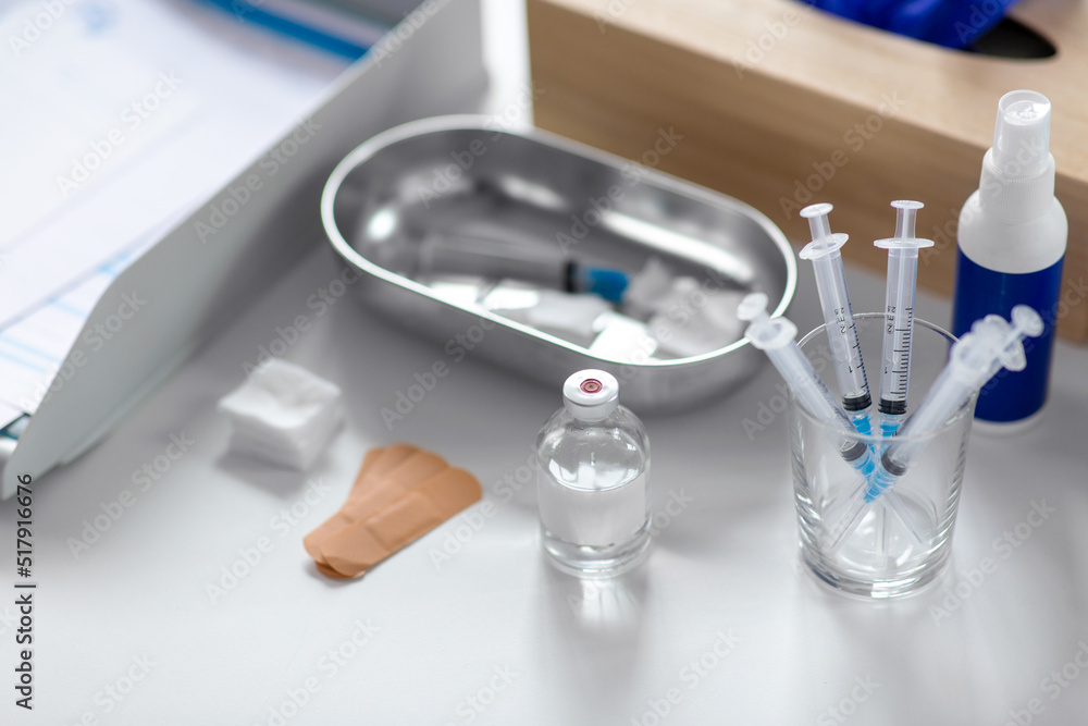 Fototapeta premium medicine and healthcare concept - close up of syringes, drug in jar and other stuff on table at hospital