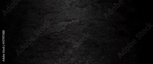 Black abstract lava stone texture background, dark black rough grainy stone or concrete wall texture background, black background with faint texture and bright center and black vignette border.	